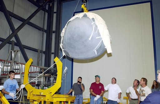 KENNEDY SPACE CENTER, FLA. - In the Orbiter Processing Facility, workers watch as the nose cap of the orbiter Atlantis is moved toward the stand at left.  The cap was removed from the orbiter for routine inspection. The nose cap is made of reinforced carbon-carbon (RCC), which has an operating range