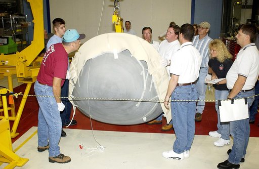 KENNEDY SPACE CENTER, FLA. - In the Orbiter Processing Facility, workers watch as the nose cap of the orbiter Atlantis is lowered toward the floor.   The cap was removed from the orbiter for routine inspection. The nose cap is made of reinforced carbon-carbon (RCC), which has an operating range of m