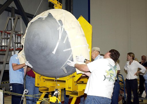 KENNEDY SPACE CENTER, FLA. -  In the Orbiter Processing Facility, workers help guide the nose cap of the orbiter Atlantis toward a stand.  The cap was removed from the orbiter for routine inspection. The nose cap is made of reinforced carbon-carbon (RCC), which has an operating range of minus 250° F