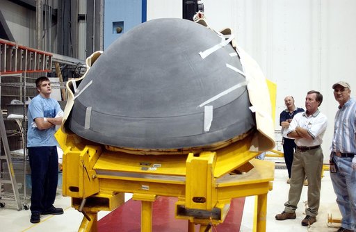 KENNEDY SPACE CENTER, FLA. - In the Orbiter Processing Facility, workers watch as the nose cap of the orbiter Atlantis is shifted to a horizontal position on a stand.  The cap was removed from the orbiter for routine inspection. The nose cap is made of reinforced carbon-carbon (RCC), which has an op