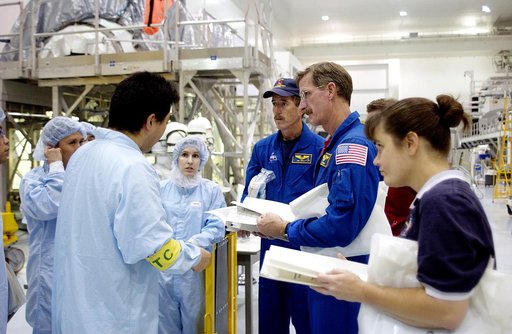 KENNEDY SPACE CENTER, FLA. - In the Space Station Processing Facility, workers (in protective clothing) brief STS-117 Mission Specialist James Reilly (center) and STS-115 Mission Specialist Joseph Tanner (right) about the Japanese Experiment Module (JEM).  Equipment familiarization is a routine part