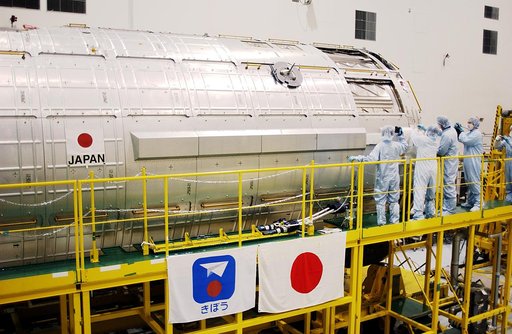 KENNEDY SPACE CENTER, FLA. -  In the Space Station Processing Facility, STS-115 Mission Specialist Joseph Tanner and STS-117 Mission Specialist James Reilly get a close look at the Japanese Experiment Module (JEM).  Reilly and Tanner are at KSC for equipment familiarization, a routine part of astron