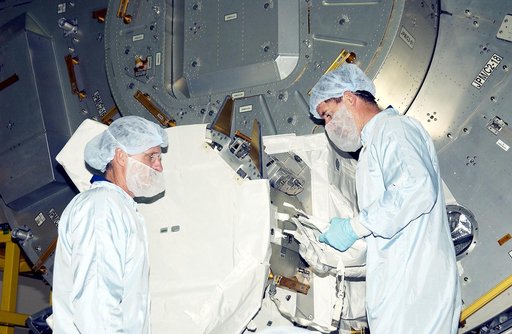 KENNEDY SPACE CENTER, FLA. -  In the Space Station Processing Facility, STS-117 Mission Specialist James Reilly (left) and STS-115 Mission Specialist Joseph Tanner (right) look over components in the Japanese Experiment Module (JEM).  Equipment familiarization is a routine part of astronaut training