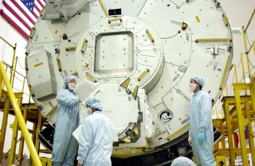 KENNEDY SPACE CENTER, FLA. - In the Space Station Processing Facility, STS-115 Mission Specialist Joseph Tanner (left) and STS-117 Mission Specialist James Reilly (right) look over the Japanese Experiment Module (JEM) behind them. Equipment familiarization is a routine part of astronaut training and
