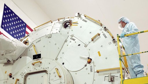 KENNEDY SPACE CENTER, FLA. -  In the Space Station Processing Facility, STS-115 Mission Specialist Joseph Tanner takes a closer look at the Japanese Experiment Module (JEM). Known as Kibo, the JEM consists of six components: two research facilities - the Pressurized Module and the Exposed Facility; 