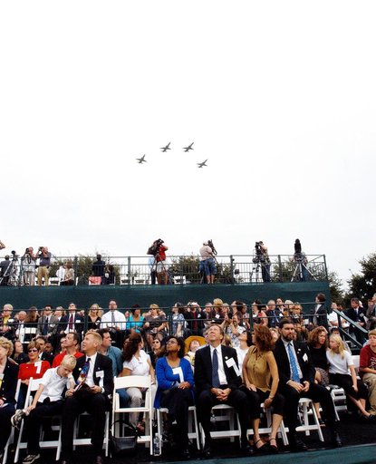 KENNEDY SPACE CENTER, FLA. -- Family members of the STS-107 astronauts and other dignitaries watch NASA T-38 jets fly over the Space Mirror Memorial at the Kennedy Space Center Visitor Complex in a Missing Man Formation. During this dedication ceremony, the names of the STS-107 astronauts who lost t