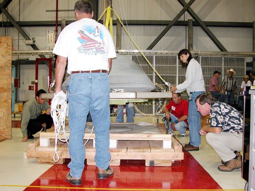 KENNEDY SPACE CENTER, FLA. -  In the Orbiter Processing Facility, the nose cap from Atlantis is lowered toward a shipping pallet.  The reinforced carbon-carbon (RCC) nose cap is being sent to the original manufacturing company, Vought in Ft. Worth, Texas, a subsidiary of Lockheed Martin, to undergo 