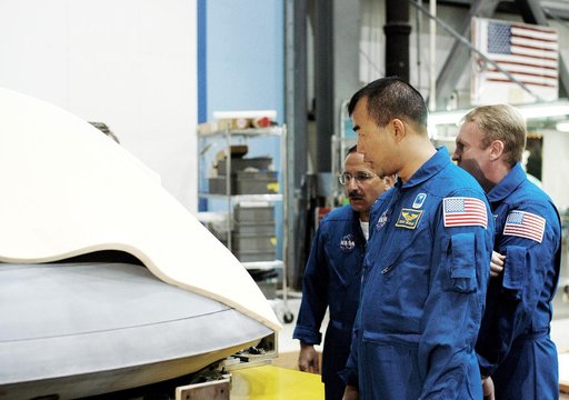 KENNEDY SPACE CENTER, FLA. -  In the Orbiter Processing Facility, STS-114 crew members look at the nose cap recently removed from Atlantis.  From left are Mission Specialists Charles Camarda, Soichi Noguchi, and Andy Thomas.  Camarda and Thomas are new additions to the crew.  Noguchi is with the Jap