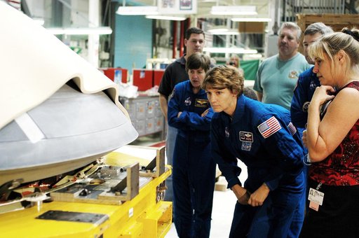 KENNEDY SPACE CENTER, FLA. -  In the Orbiter Processing Facility, STS-114 crew members look at the nose cap recently removed from Atlantis.  From left are Mission Specialist Wendy Lawrence, Commander Eileen Collins and Pilot James Kelly (behind Collins).  Lawrence is a new addition to the mission cr