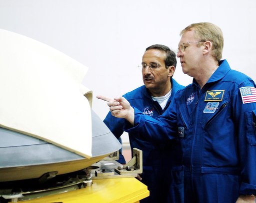KENNEDY SPACE CENTER, FLA. -  In the Orbiter Processing Facility, STS-114 Mission Specialists Charles Camarda and Andy Thomas, who were recently added to the crew, look at the nose cap recently removed from Atlantis.  The STS-114 crew is at KSC to take part in crew equipment and orbiter familiarizat