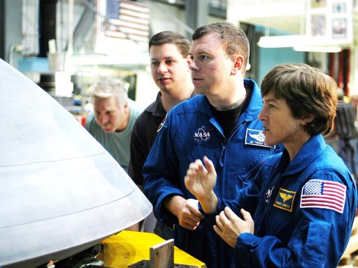 KENNEDY SPACE CENTER, FLA. -  In the Orbiter Processing Facility, STS-114 Pilot James Kelly (center) and Mission Specialist Wendy Lawrence, who was recently added to the mission crew, look at the nose cap recently removed from Atlantis. The STS-114 crew is at KSC to take part in equipment familiariz