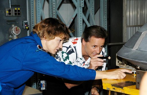KENNEDY SPACE CENTER, FLA. -  In the Orbiter Processing Facility, STS-114 Commander Eileen Collins examines part of the Atlantis nose cap with Randall Carter, who is with The  Boeing Company.  The nose cap was  recently removed from Atlantis.  The STS-114 crew is at KSC to take part in crew equipmen