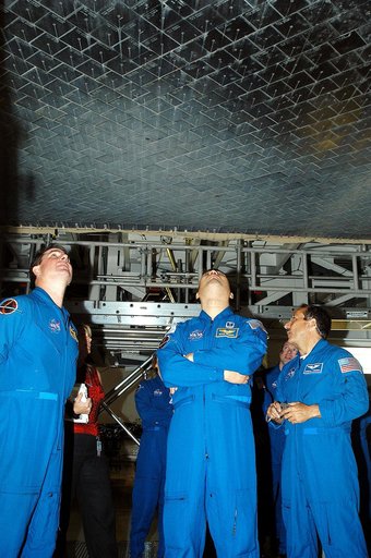KENNEDY SPACE CENTER, FLA. -  In the Orbiter Processing Facility, STS-114 crew members look at the tiles underneath Atlantis.  From left are Mission Specialists Stephen Robinson, Soichi Noguchi and Charles Camarada, who is a new addition to the crew.  Noguchi is with the Japan Aerospace Exploration 