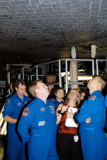 KENNEDY SPACE CENTER, FLA. -  In the Orbiter Processing Facility, STS-114 crew members look at the tiles underneath Atlantis.  From left (in flight suits) are Mission Specialists Stephen Robinson and Andy Thomas, Commander Eileen Collins and, at right, Mission Specialist Soichi Noguchi, who is with 