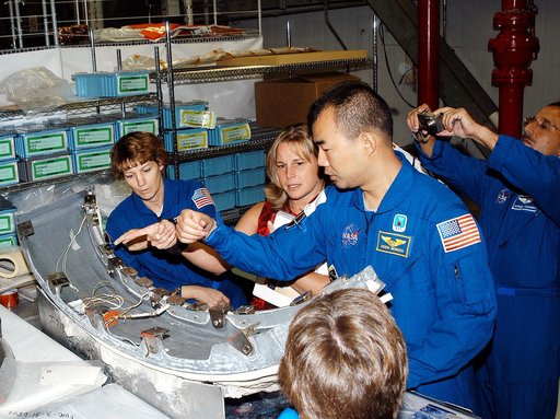 KENNEDY SPACE CENTER, FLA. - Members of the STS-114 crew look over flight  equipment in the Orbiter Processing Facility.  From left are Mission Commander Eileen Collins; Glenda Laws, EVA Task Leader, with United Space Alliance at Johnson Space Center; and Mission Specialists Soichi Noguchi and Charl