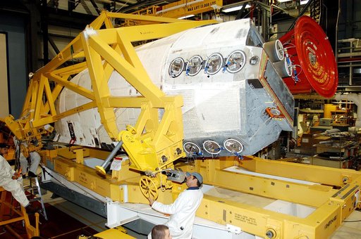 KENNEDY SPACE CENTER, FLA. - In the Orbiter Processing Facility, one of two orbital maneuvering system (OMS) pods is being moved for installation on Atlantis.  The OMS pods are attached to the upper aft fuselage left and right sides. Fabricated primarily of graphite epoxy composite and aluminum, eac