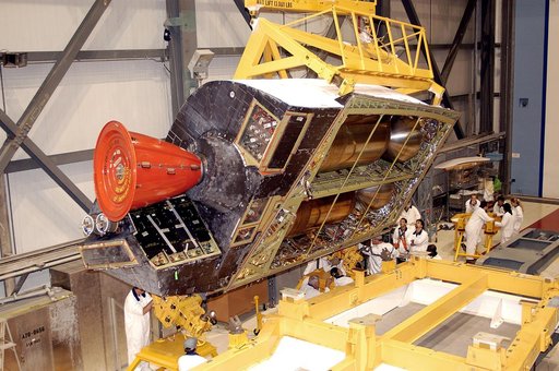 KENNEDY SPACE CENTER, FLA. -  In the Orbiter Processing Facility, one of two orbital maneuvering system (OMS) pods is lifted off its stand to move it toward Atlantis for installation. The OMS pods are attached to the upper aft fuselage left and right sides. Fabricated primarily of graphite epoxy com