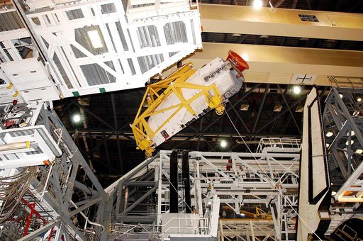 KENNEDY SPACE CENTER, FLA. -  In the Orbiter Processing Facility, an orbital maneuvering system (OMS) pod is suspended in air as it is moved toward Atlantis for installation.  Two OMS pods are attached to the upper aft fuselage left and right sides. Fabricated primarily of graphite epoxy composite a