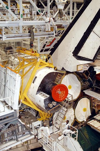 KENNEDY SPACE CENTER, FLA. - In the Orbiter Processing Facility, an orbital maneuvering system (OMS) pod is moved into place on Atlantis.  It is one of two OMS pods attached to the upper aft fuselage left and right sides. Fabricated primarily of graphite epoxy composite and aluminum, each pod is 21.