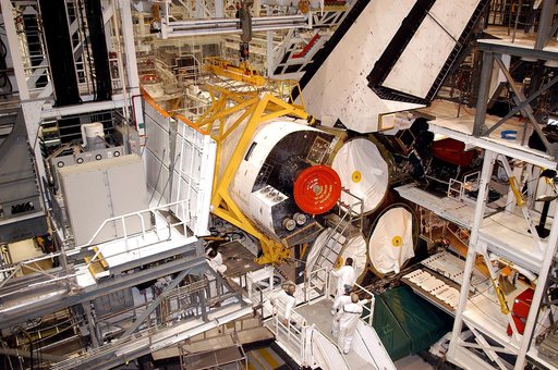 KENNEDY SPACE CENTER, FLA. - In the Orbiter Processing Facility, an orbital maneuvering system (OMS) pod is moved into place on Atlantis.  It is one of two OMS pods attached to the upper aft fuselage left and right sides. Fabricated primarily of graphite epoxy composite and aluminum, each pod is 21.