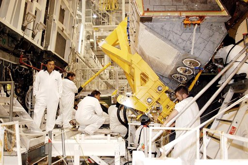 KENNEDY SPACE CENTER, FLA. - In the Orbiter Processing Facility, technicians make final adjustments to the orbital maneuvering system (OMS) pod being installed on Atlantis.   The OMS pod is one of two that are attached to the upper aft fuselage left and right sides. Fabricated primarily of graphite 