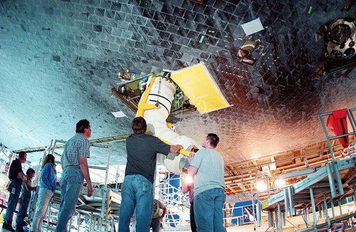 KENNEDY SPACE CENTER, FLA. - In the Orbiter Processing Facility, workers install the liquid oxygen feedline for the 17-inch disconnect on orbiter Discovery. The 17-inch liquid oxygen and liquid hydrogen disconnects provide the propellant feed interface from the external tank to the orbiter main prop
