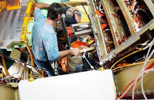 KENNEDY SPACE CENTER, FLA. -  Viewed from inside the aft section of the orbiter Discovery, a worker installs the liquid oxygen feedline for the 17-inch disconnect, coming up from below. The 17-inch liquid oxygen and liquid hydrogen disconnects provide the propellant feed interface from the external 