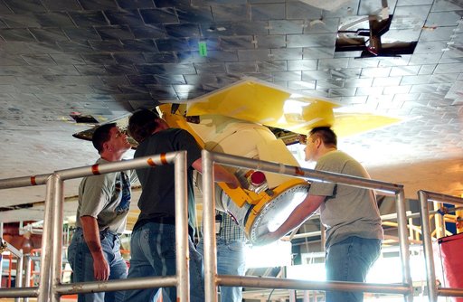 KENNEDY SPACE CENTER, FLA. -  Workers in the Orbiter Processing Facility insert the liquid oxygen feedline for the 17-inch disconnect in the orbiter Discovery.  The 17-inch liquid oxygen and liquid hydrogen disconnects provide the propellant feed interface from the external tank to the orbiter main 