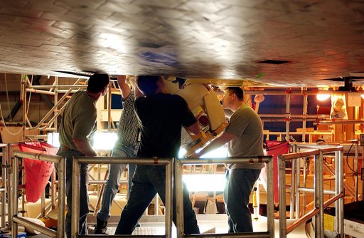 KENNEDY SPACE CENTER, FLA. -  Workers in the Orbiter Processing Facility insert the liquid oxygen feedline for the 17-inch disconnect in the orbiter Discovery.  The 17-inch liquid oxygen and liquid hydrogen disconnects provide the propellant feed interface from the external tank to the orbiter main 