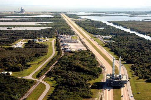 KENNEDY SPACE CENTER, FLA. -  The crawler transporter slowly moves the Mobile Launcher Platform (MLP), carrying a set of twin solid rocket boosters, away from the Vehicle Assembly Building (VAB) in support of engineering analysis vibration tests on the crawler and MLP.   In the distance, at left, is