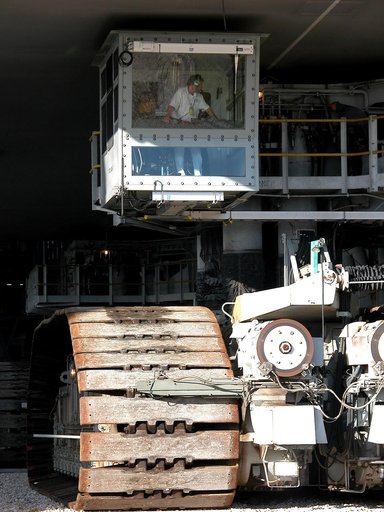 KENNEDY SPACE CENTER, FLA. -  As the crawler transporter slowly moves the Mobile Launcher Platform (MLP) out of the Vehicle Assembly Building, the driver of the front control cab can be seen.  The MLP is carrying two solid rocket boosters for engineering analysis vibration tests on the crawler and M