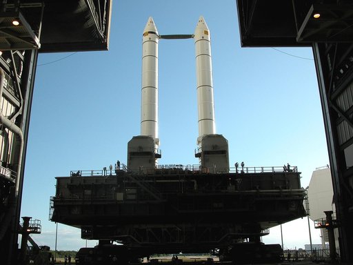 KENNEDY SPACE CENTER, FLA. -  The crawler transporter slowly moves the Mobile Launcher Platform (MLP), carrying a set of twin solid rocket boosters, away from the Vehicle Assembly Building (VAB) in support of engineering analysis vibration tests on the crawler and MLP.   The crawler is moving at var