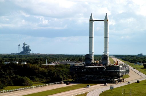 KENNEDY SPACE CENTER, FLA. -  The crawler transporter slowly moves the Mobile Launcher Platform (MLP), carrying a set of twin solid rocket boosters, along the crawlerway in support of engineering analysis vibration tests on the crawler and MLP.   In the distance, at left, is Launch Pad 39A. The craw