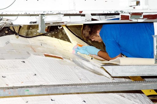 KENNEDY SPACE CENTER, FLA. - In the Orbiter Processing Facility, United Space Alliance technician Jamie Haynes does a gap test on the tiles of the nose of orbiter Atlantis as part of return-to-flight activities.  Atlantis is scheduled for mission STS-114, a return-to-flight test mission to the Inter