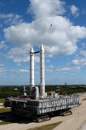 KENNEDY SPACE CENTER, FLA. -  A high-flying bird takes a closer look at the Mobile Launcher Platform (MLP) number 3 with twin solid rocket boosters bolted to it as it crawls toward Launch Pad 39A, in the background.  The crawler is moving along the crawlerway at various speeds up to 1 mph in an effo
