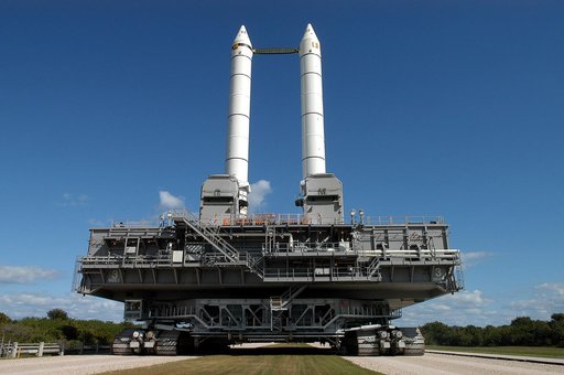 KENNEDY SPACE CENTER, FLA. -  Like candles embedded in a sculptured “cake,” the Mobile Launcher Platform (MLP) number 3 with twin solid rocket boosters bolted to it inches along the crawlerway at various speeds up to 1 mph in an effort to achieve vibration data gathering goals. The boosters are brac