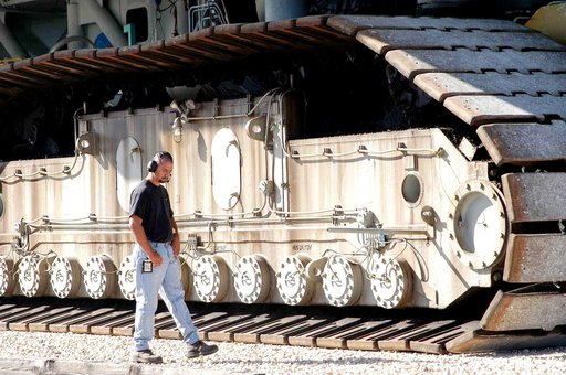 KENNEDY SPACE CENTER, FLA. - A Kennedy Space Center technician walks towards the intersection of the crawlerway beside a crawler-transporter moving Mobile Launcher Platform (MLP) number 3, with a set of twin solid rocket boosters bolted atop, during the second engineering analysis vibration test on 