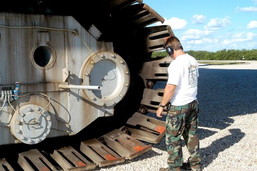KENNEDY SPACE CENTER, FLA. - A Kennedy Space Center technician inspects the shoes on one of eight tracks of a crawler-transporter (CT).  The CT is moving Mobile Launcher Platform (MLP) number 3 with a set of twin solid rocket boosters bolted on top to the intersection in the crawlerway in support of