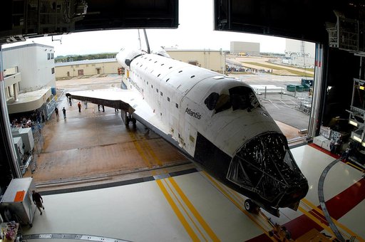 KENNEDY SPACE CENTER, FLA. - The Space Shuttle orbiter Atlantis backs out of the Orbiter Processing Facility (OPF) for its move to the Vehicle Assembly Building (VAB). The move will allow work to be performed in the OPF that can only be accomplished while the bay is empty. Work scheduled in the proc