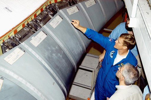 KENNEDY SPACE CENTER, FLA. -  In the Orbiter Processing Facility, astronaut Scott E. Parazynski points to the Reinforced Carbon Carbon panels used on the leading edge of the wing of the orbiters. With Parazynski are engineers from around the Agency who are working on improving the RCC panels used on