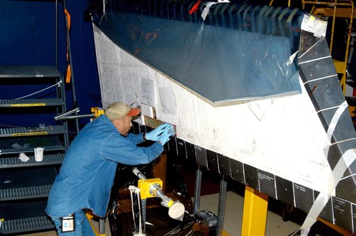 KENNEDY SPACE CENTER, FLA. -  In the Orbiter Processing Facility, KSC employee Joel Smith prepares an area on the orbiter Discovery for blanket installation.  The blankets are part of the Orbiter Thermal Protection System, thermal shields to protect against temperatures as high as 3,000° Fahrenheit,
