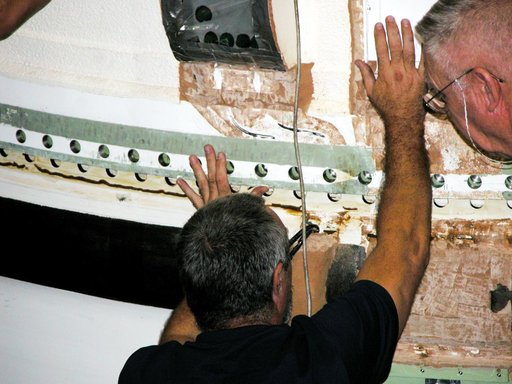 KENNEDY SPACE CENTER, FLA. -  In the Vehicle Assembly Building, a KSC employee separates the forward assembly (nose cap and frustum) from a solid rocket booster (SRB) after removing the bolts.  The destacking is part of time and cycle activities.  The SRB was part of the stack on Atlantis originally