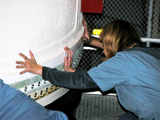 KENNEDY SPACE CENTER, FLA. -  In the Vehicle Assembly Building, a KSC employee separates the forward assembly (nose cap and frustum) from a solid rocket booster (SRB) after the bolts were removed.  The destacking is part of time and cycle activities.  The SRB was part of the stack on Atlantis origin