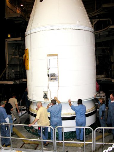 KENNEDY SPACE CENTER, FLA. -  In the Vehicle Assembly Building, KSC employees help guide the destacking of the forward assembly (nose cap and frustum) from a solid rocket booster (SRB) after the bolts were removedThe destacking is part of time and cycle activities.  The SRB was part of the stack on 