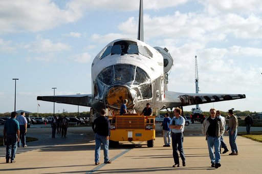 KENNEDY SPACE CENTER, FLA. -  Workers accompany the orbiter Atlantis as it is towed back to the Orbiter Processing Facility after spending 10 days in the Vehicle Assembly Building.  The hiatus in the VAB allowed work to be performed in the OPF that can only be accomplished while the bay is empty. Wo