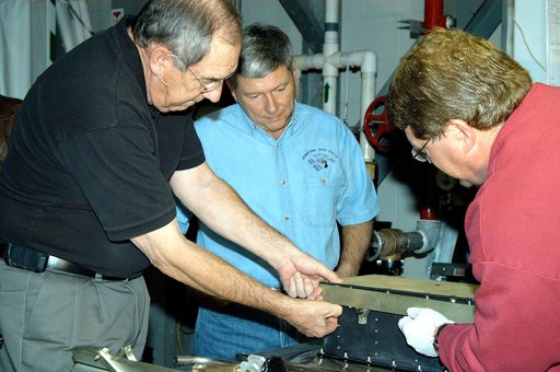 KENNEDY SPACE CENTER, FLA. -- United Space Alliance (USA) Vice President and Space Shuttle Program Manager Howard DeCastro (left) and NASA Deputy Associate Administrator for Space Station and Shuttle Programs Michael Kostelnik (center) are briefed on the use of a cold plate in Orbiter Processing Fac