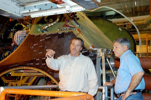 KENNEDY SPACE CENTER, FLA. -- NASA Deputy Associate Administrator for Space Station and Shuttle Programs Michael Kostelnik (right) discusses a speed brake on Shuttle Discovery in Orbiter Processing Facility Bay 3 with a United Space Alliance (USA) technician (left).  NASA and USA Space Shuttle progr