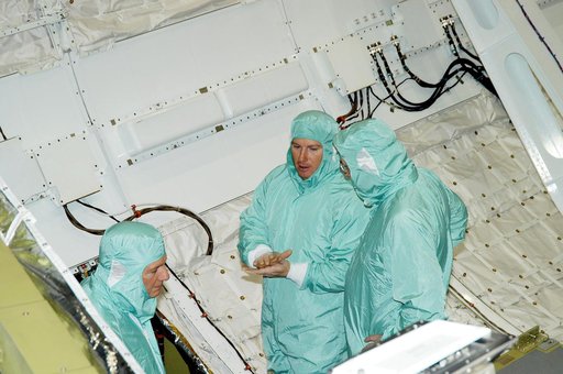 KENNEDY SPACE CENTER, FLA. -- In Orbiter Processing Facility Bay 1, NASA Deputy Associate Administrator for Space Station and Shuttle Programs Michael Kostelnik (left) and United Space Alliance (USA) Vice President and Space Shuttle Program Manager Howard DeCastro (right) are briefed by a USA techni