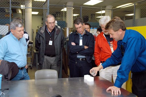 KENNEDY SPACE CENTER, FLA. -- From left, NASA Deputy Associate Administrator for Space Station and Shuttle Programs Michael Kostelnik and United Space Alliance (USA) Vice President and Space Shuttle Program Manager Howard DeCastro are briefed on the properties of the tile used in the Shuttle's Therm