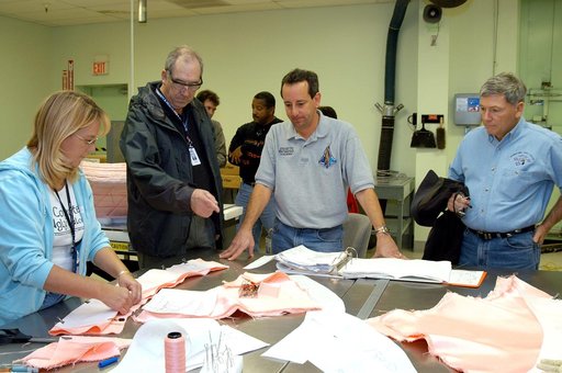 KENNEDY SPACE CENTER, FLA. -- United Space Alliance (USA) technicians demonstrate the construction of a thermal blanket used in the Shuttle's thermal protection system for USA Vice President and Space Shuttle Program Manager Howard DeCastro (second from left) and NASA Deputy Associate Administrator 